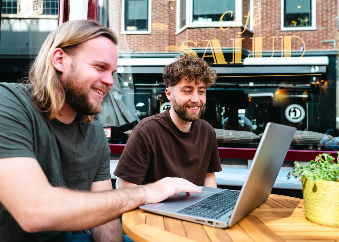 Stijn and Daniël from Boost Your Language working together at a cafe